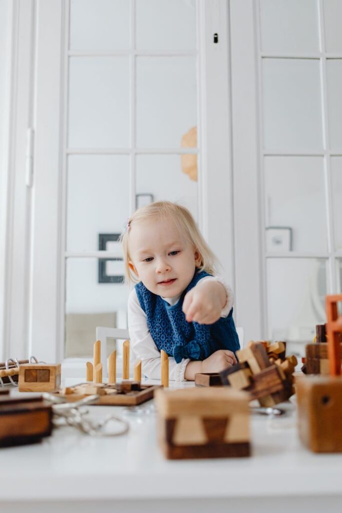 A child playing with wooden educational toys indoors, fostering creativity and learning.